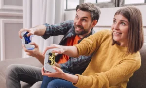 Man-is-gaming-with-blue-controller-and-woman-with-a-golden-one